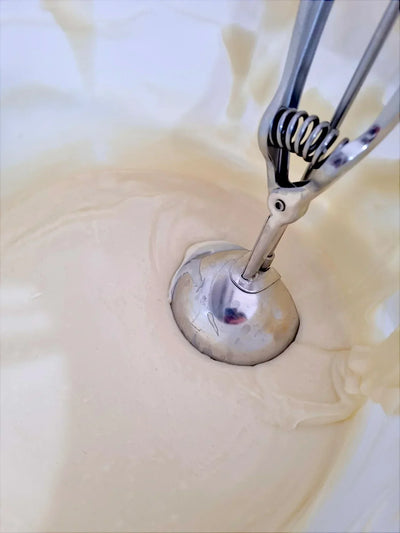 Pasta di nocciola cremosa in ciotola con porzionatore d'acciaio, ingrediente per dolci e gelati