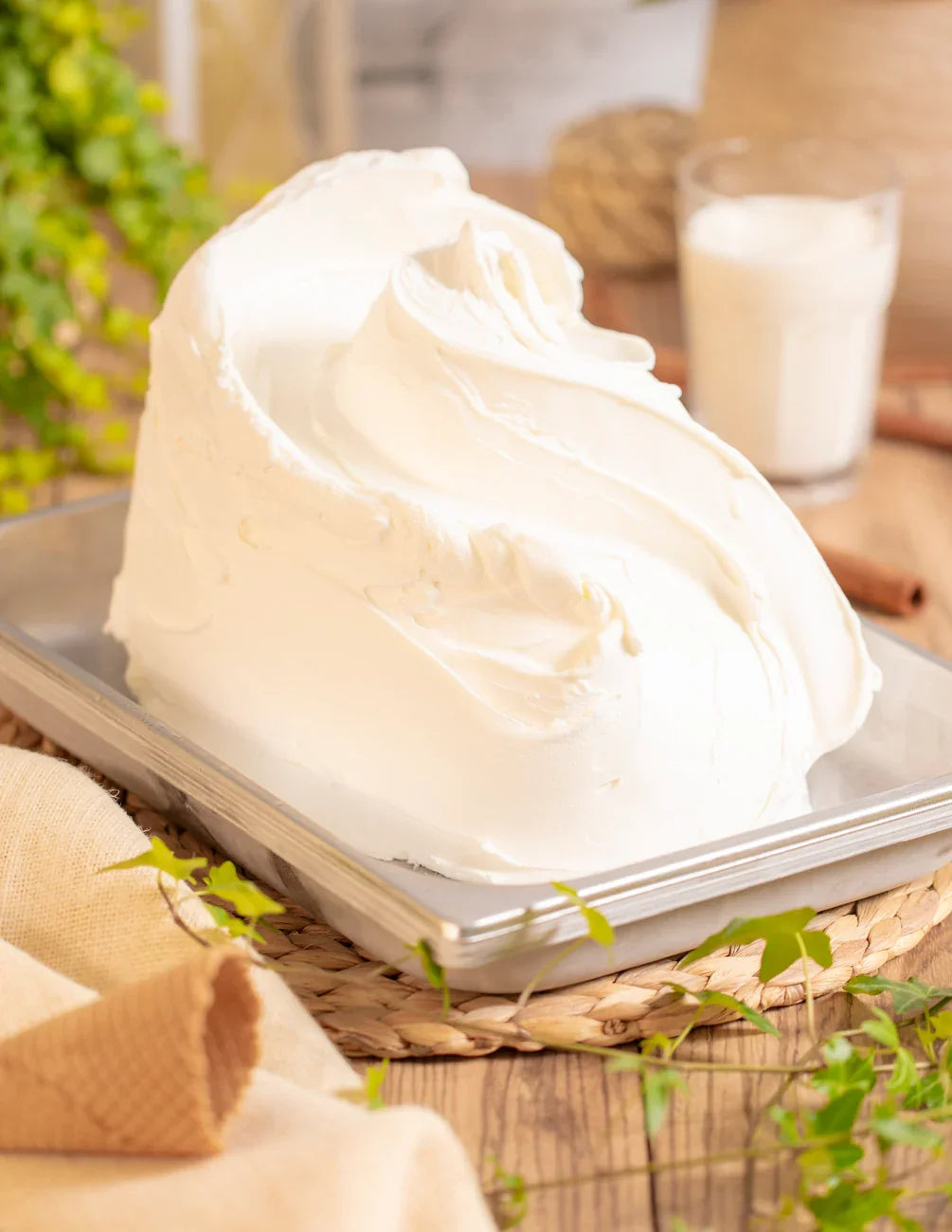 Gelato artigianale bianco in vaschetta su tavolo rustico, ingredienti naturali, ideale per pasticceria