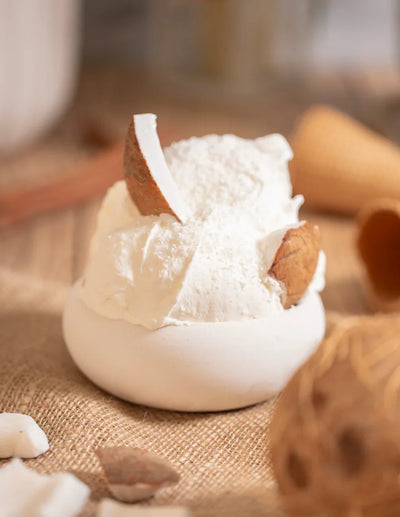 Gelato artigianale alla noce di cocco con scaglie di cocco su fondo rustico, ingredienti dolci