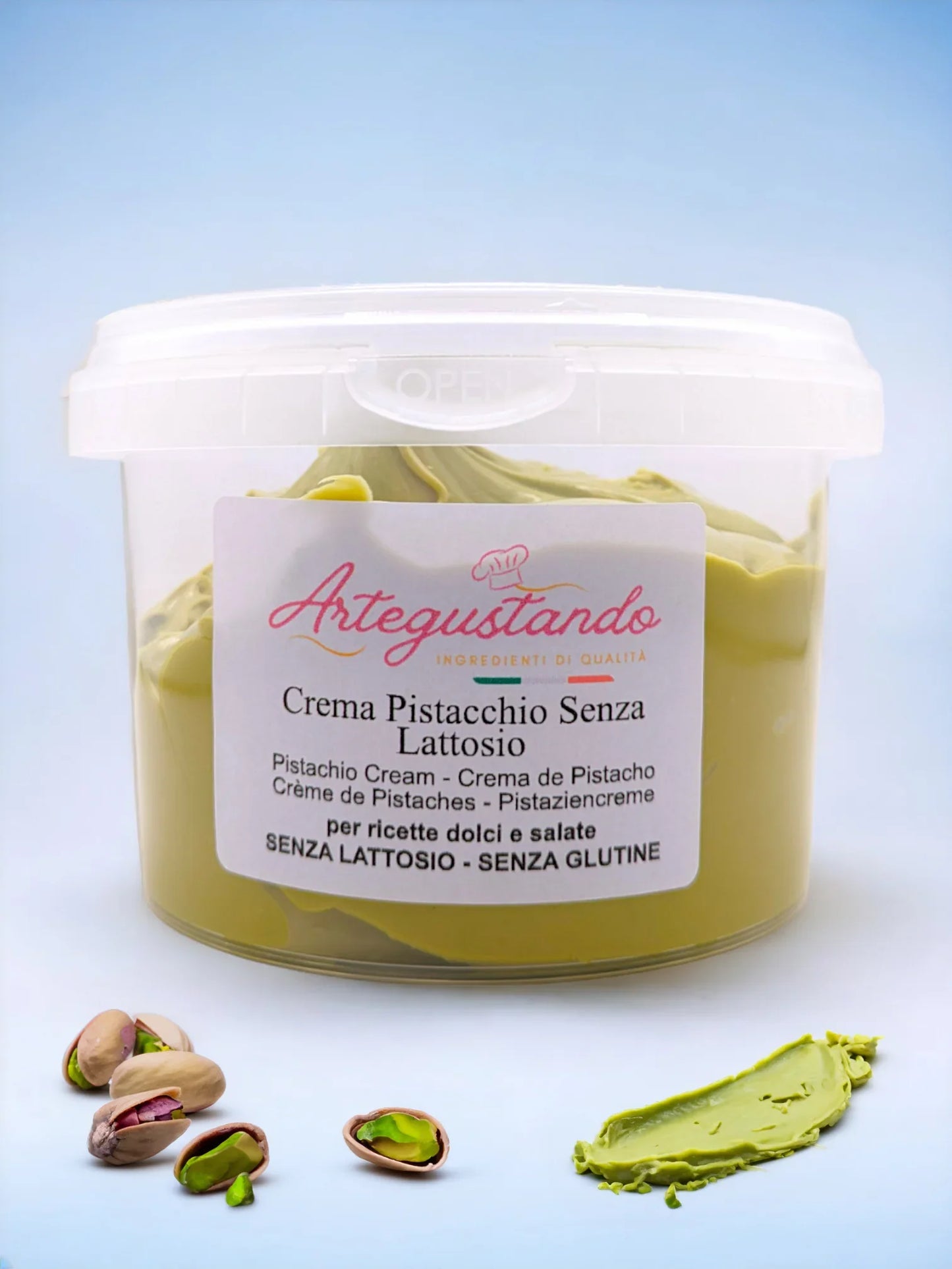 Crema di pistacchio senza lattosio in vasetto, con pistacchi e crema spalmata su sfondo chiaro.
