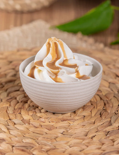 Ciotola con panna montata e topping alla nocciola per dolci, gelato e pasticceria.