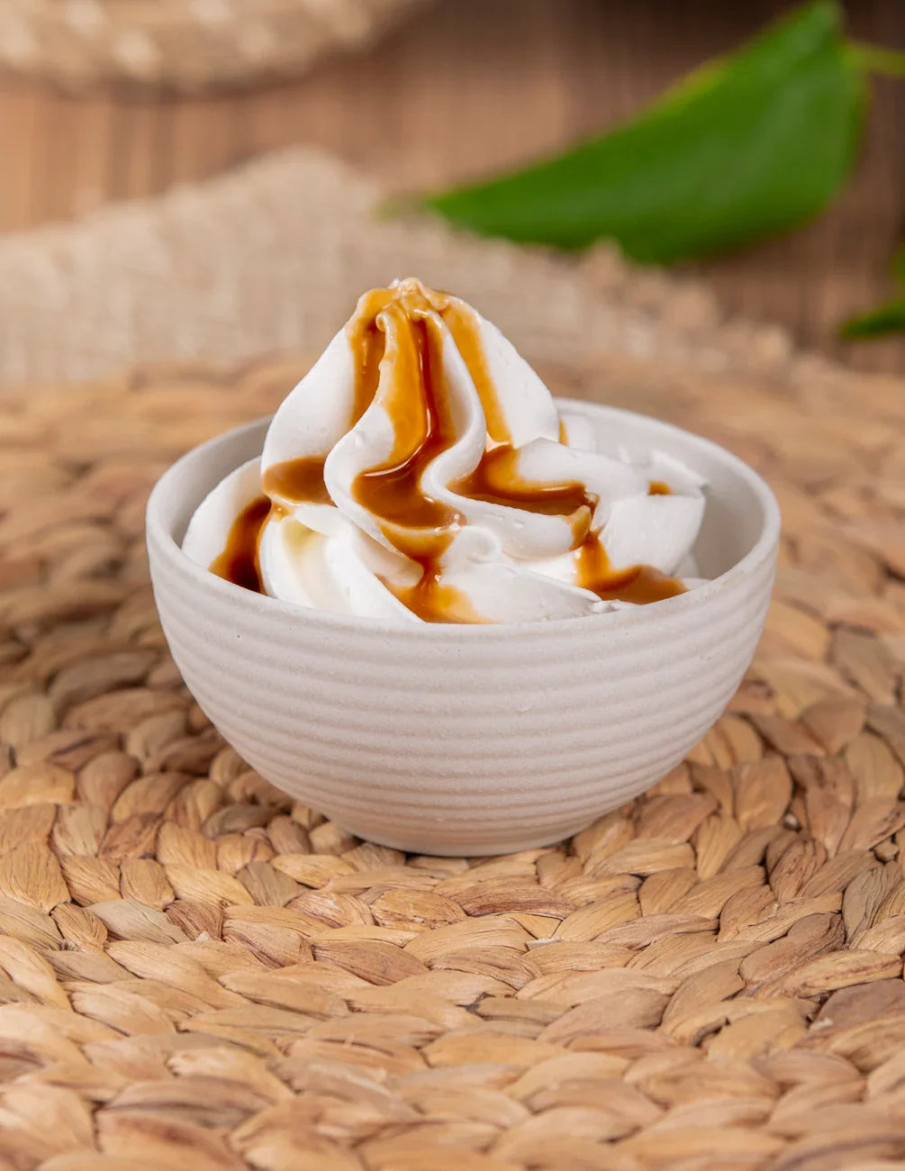 Ciotola di panna montata con salsa al caffè su base intrecciata, ideale per dolci e pasticceria.
