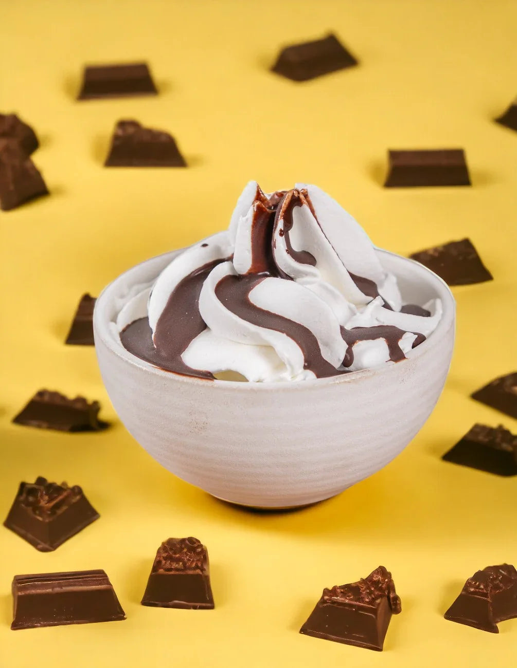 Ciotola di gelato alla panna con topping al cacao e pezzi di cioccolato su sfondo giallo