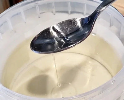 Cremosa pasta di nocciola chiara in un contenitore, versata con un cucchiaio