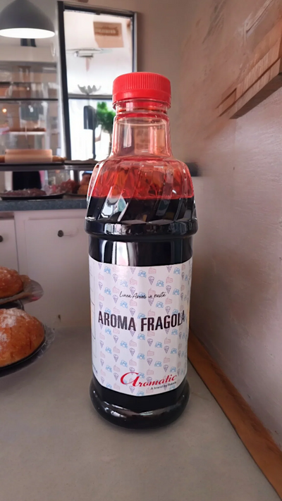 Bottiglia di aroma fragola per gelato e pasticceria su banco di una pasticceria.