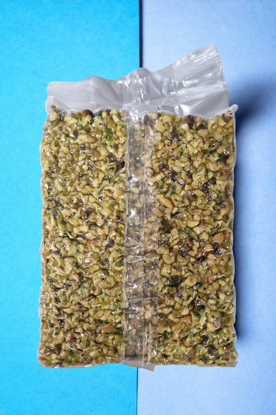 Granella di pistacchio italiana in busta sottovuoto su sfondo azzurro, ingrediente per dolci e gelato