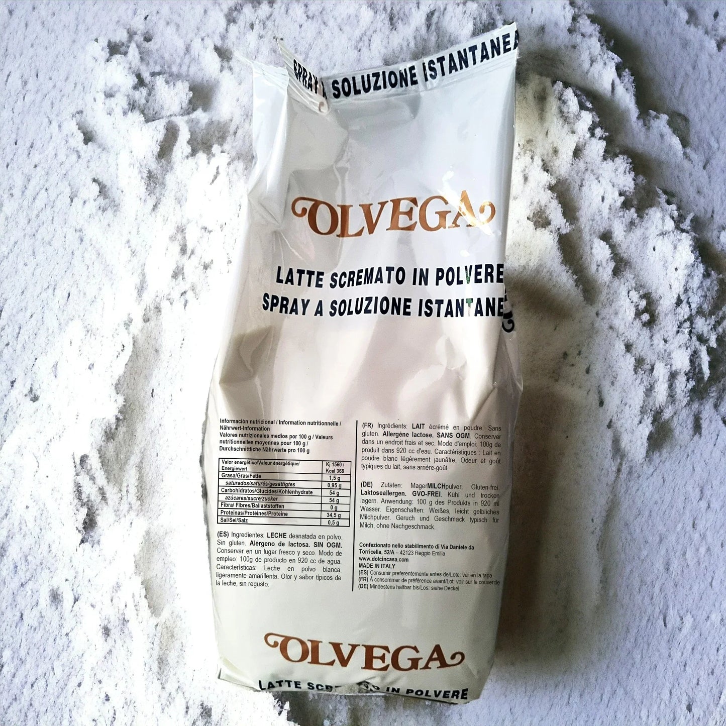 Sacco di latte scremato in polvere Olvega su fondo di polvere bianca, ingrediente per dolci e gelato