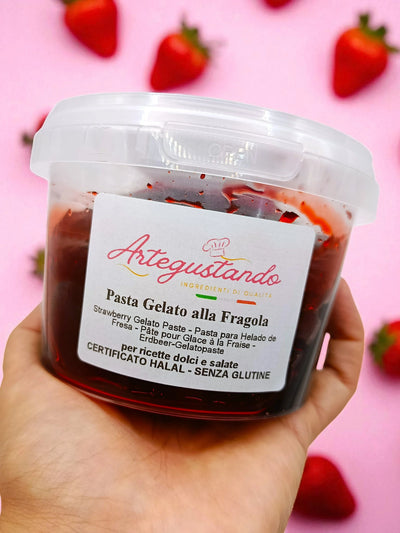 Barattolo di pasta gelato alla fragola tenuto in mano, sfondo rosa con fragole fresche