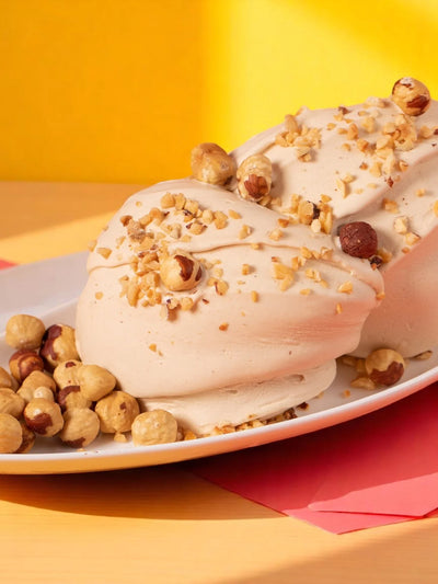 Gelato alla nocciola artigianale su piatto, decorato con nocciole intere e granella