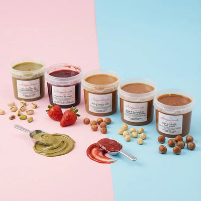 Vasetti di paste per gelato alla nocciola, pistacchio e fragola su sfondo colorato con frutta fresca