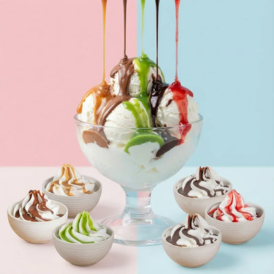 Coppa gelato con topping colorati al pistacchio, nocciola, cioccolato e frutti rossi, contornata da ciotoline con panna e salse per pasticceria.