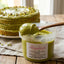 Crema di pistacchio senza lattosio in vasetto, con torta al pistacchio sullo sfondo