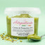 Crema di pistacchio spalmabile senza glutine in vaschetta trasparente, con cucchiaio e granella di pistacchio su sfondo verde.