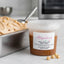 Pasta di nocciola italiana in vasetto da 250g su tavolo, vicino a gelato artigianale e nocciole intere.