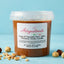 Vasetto di pasta di nocciola pura Piemonte Tonda Gentile 100% senza glutine, con nocciole intere sparse su sfondo azzurro.