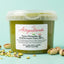 Vasetto di pasta di pistacchio mediterraneo pura 100% senza glutine con pistacchi interi e granella su sfondo azzurro.